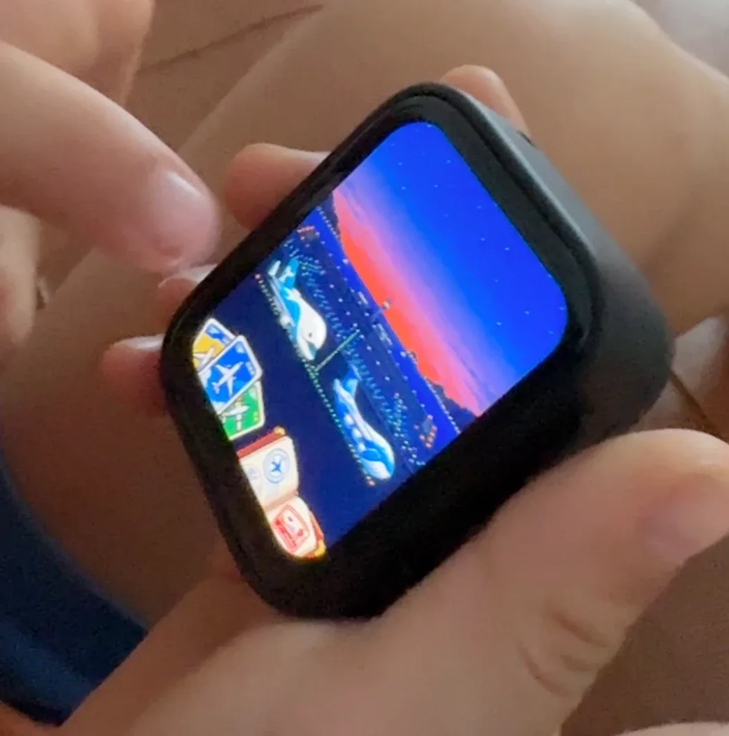 A Limes handheld in a child’s hands, showing a game